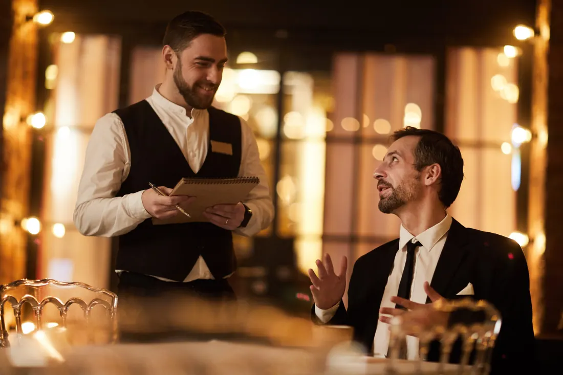 Servicekraft im Gespräch mit einem Gast