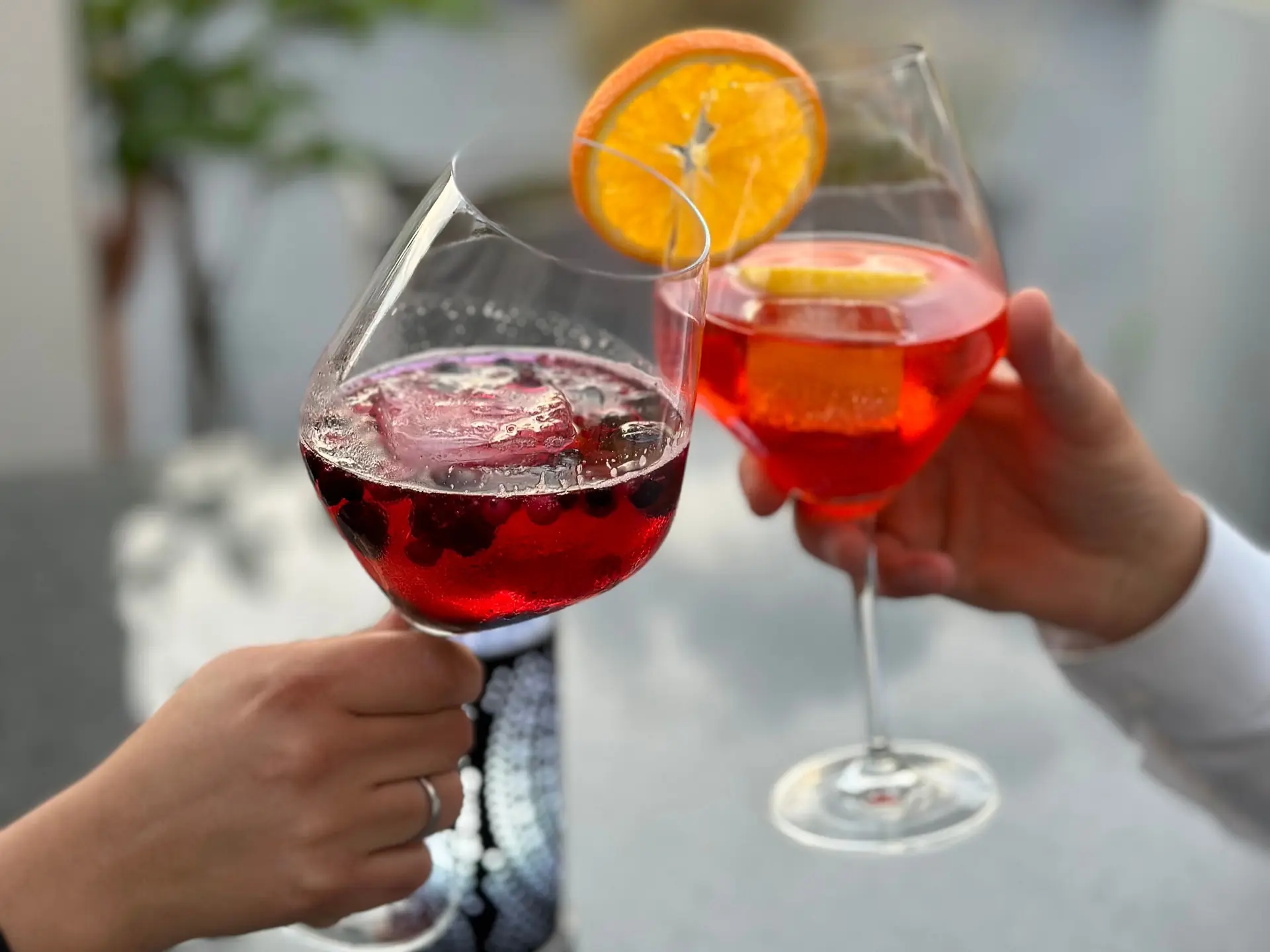 Zwei Gäste stoßen im Aragosta mit Aperol Spritz und einem roten Beeren-Spritz an